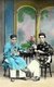 Vietnam: Two men seated, probably Parsis or Indian Jews, wearing men's ao dai or Vietnamese 'long dress', Hanoi, 1910